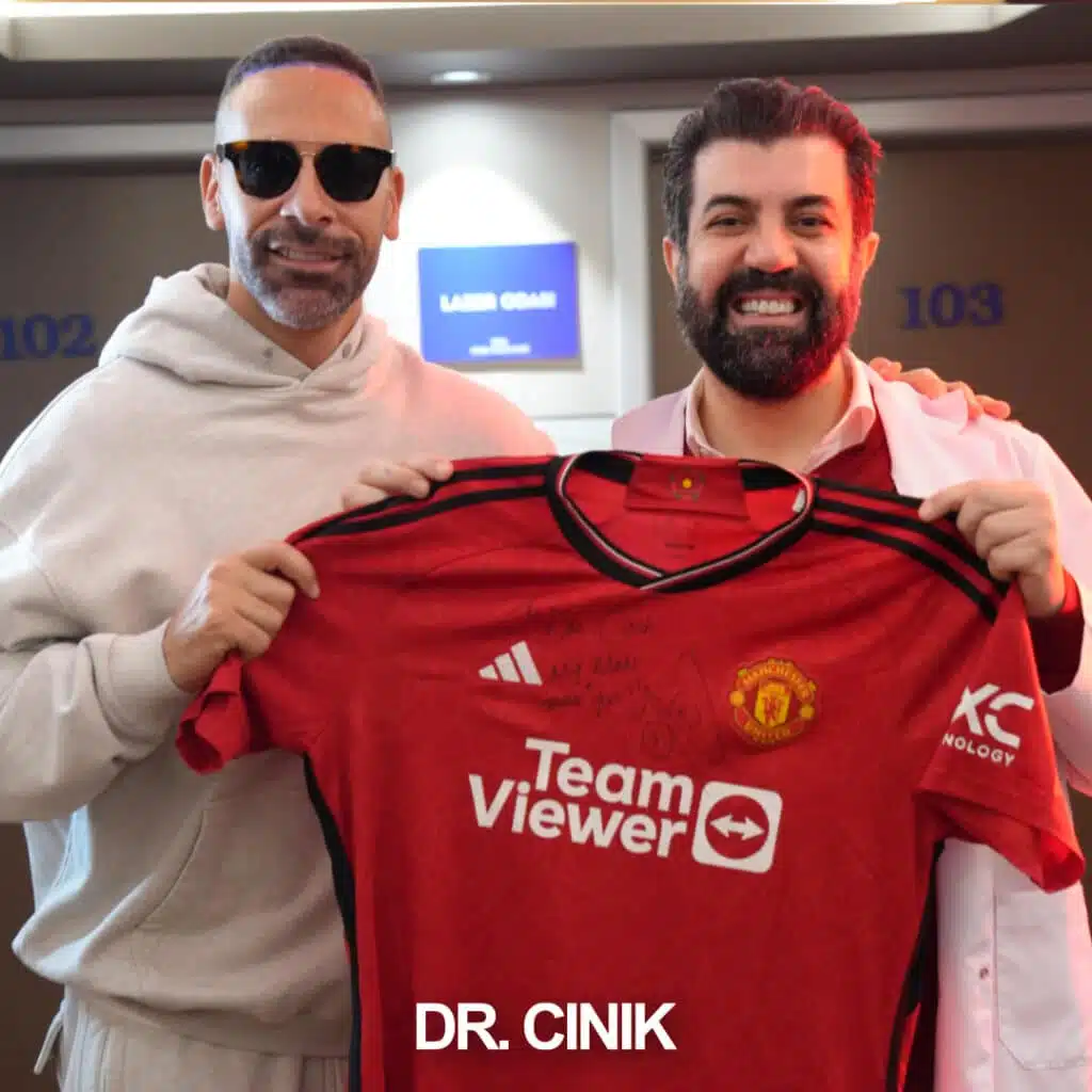Dr. Cinik posing with Manchester United legend and sports pundit Rio Ferdinand holding a Manchester United jersey at Dr. Cinik's hair transplant clinic in Istanbul, Turkey